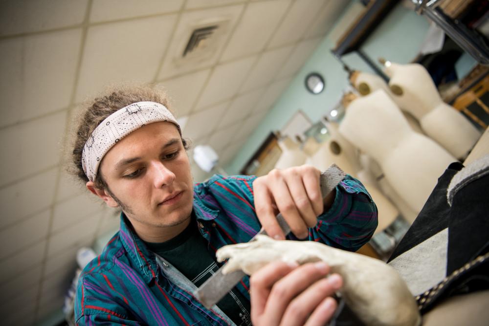 Student works on creating their costume in the costume shop for a theatre performance.